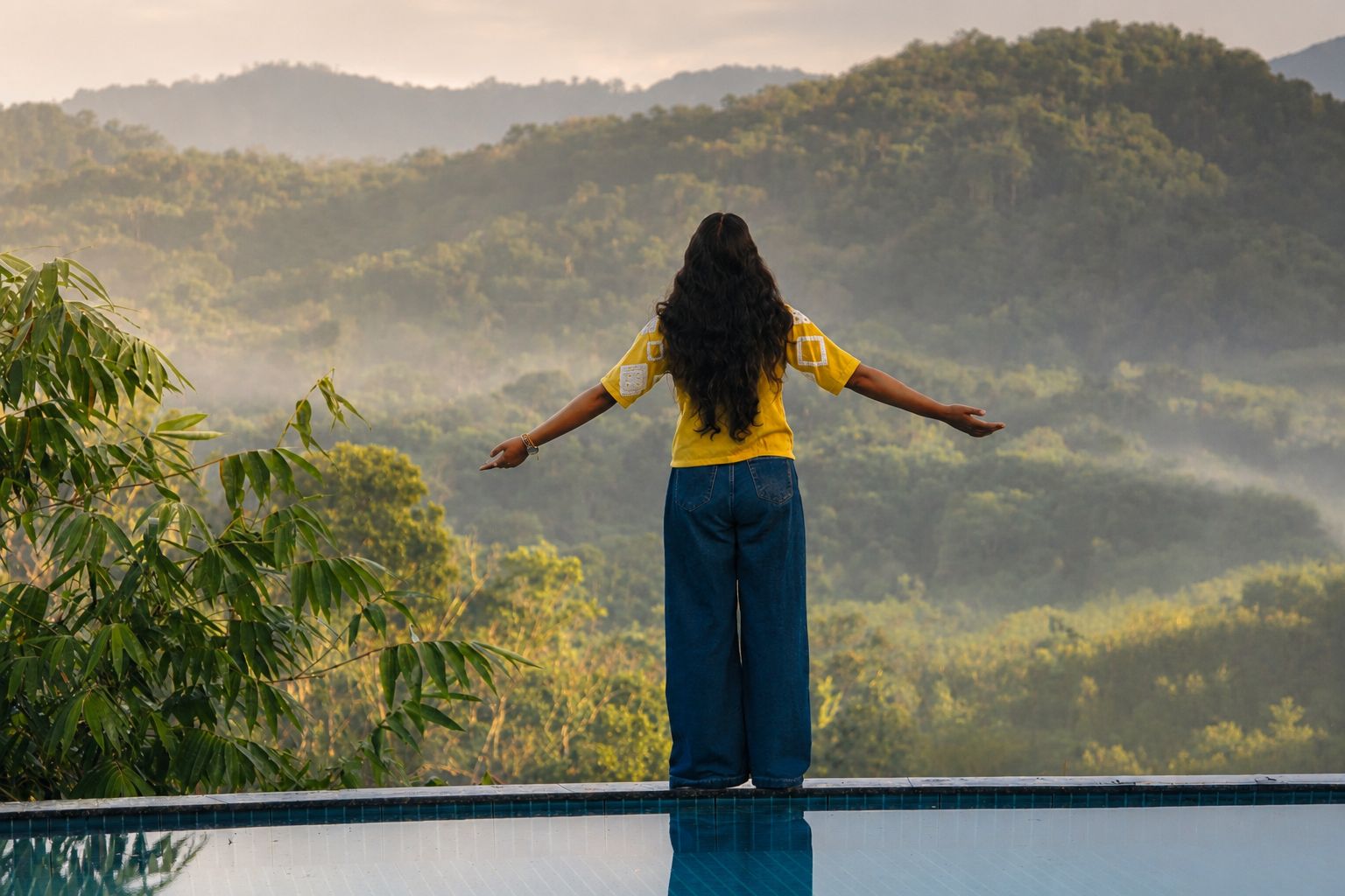 Guest overlooking the infinity pool and misty Wayanad hills
